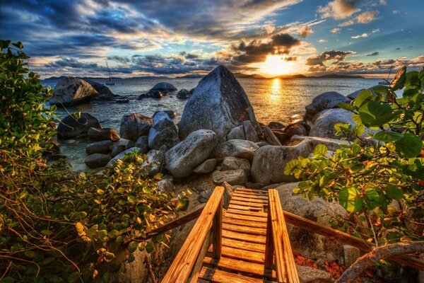 Деревянная лестница на каменное морское побережье