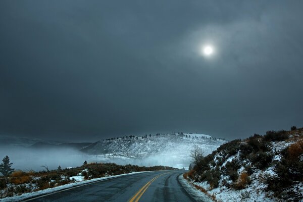 A deserted winter road under a cold moon