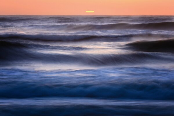 Surf de la mer et le soleil qui se couche derrière l horizon