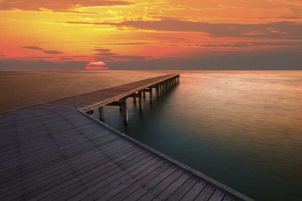 Beautiful seascape with pier and setting sun