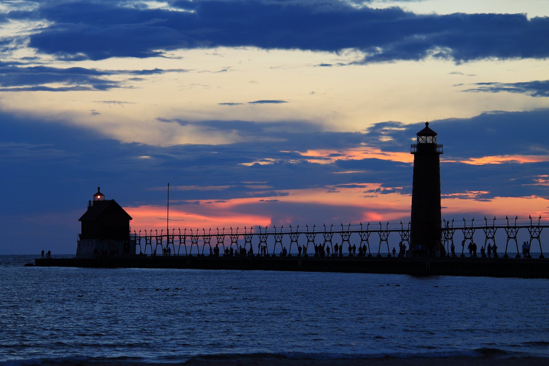 sera tramonto arancione cielo nuvole mare faro luce molo molo persone