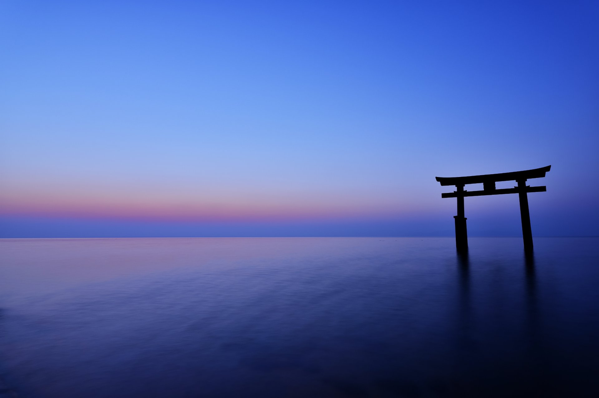 japón torii tarde puesta de sol horizonte mar océano calma cielo azul