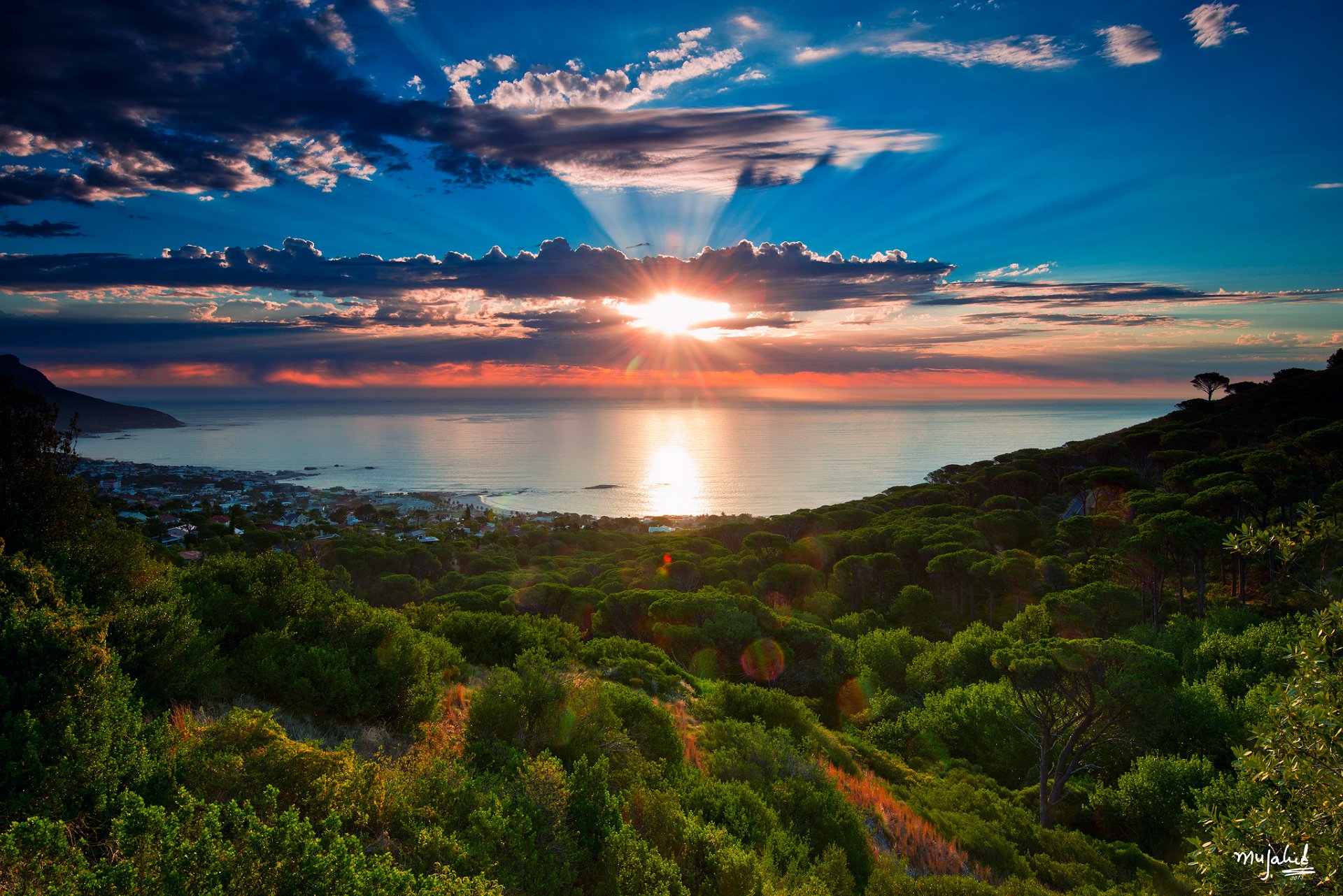 sud africa città del capo camps bay oceano atlantico baia mare oceano alberi inverno gennaio cielo nuvole sole raggi mujahid ur-rehman fotografia