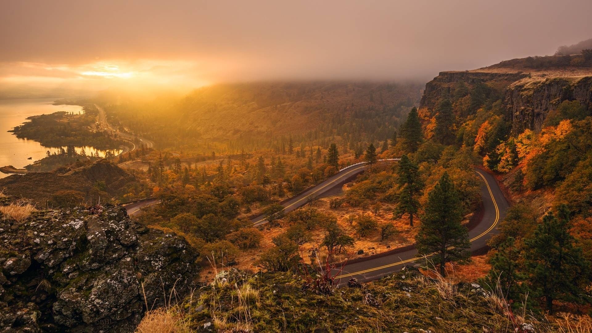 paisaje carretera pista árboles sol puesta de sol cielo montañas agua luz