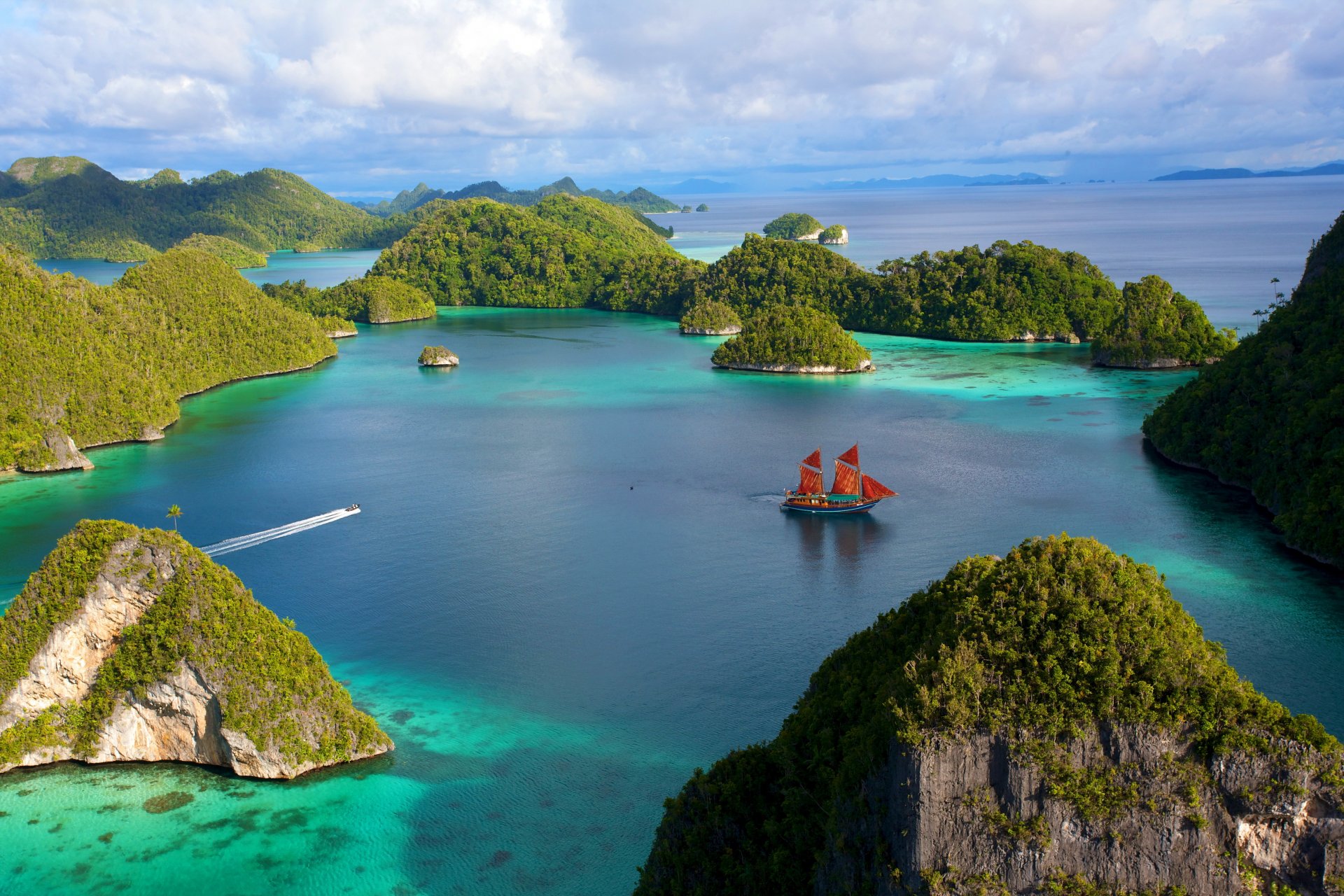 indonésie îles roches pierres végétation lagon eau navire voilier bateau ciel nuages