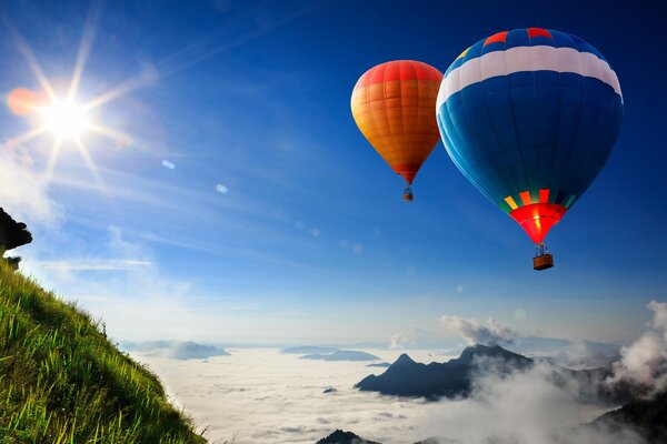 Volar globos contra el cielo y la pendiente verde