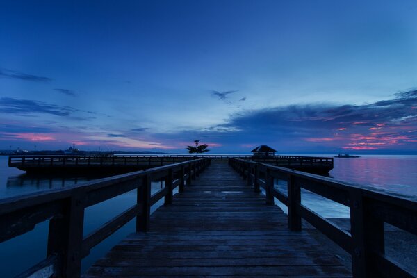 Wooden pier on sunset background