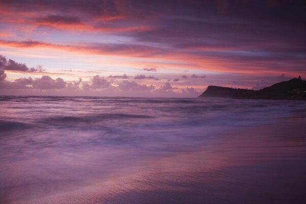 Фиолетовый закат на берегу моря где невидно облаков