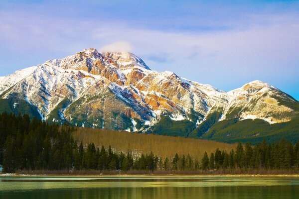 Beautiful mountains and forest are reflected in the quiet river