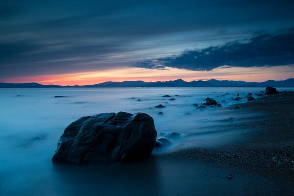 Sunset on the sea. An empty beach with rocks