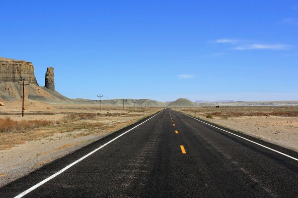 Schwarze Autobahn in der Wüste mit Felsen