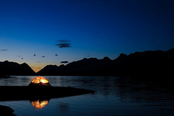 Paysage de lac dans les ténèbres avec tente