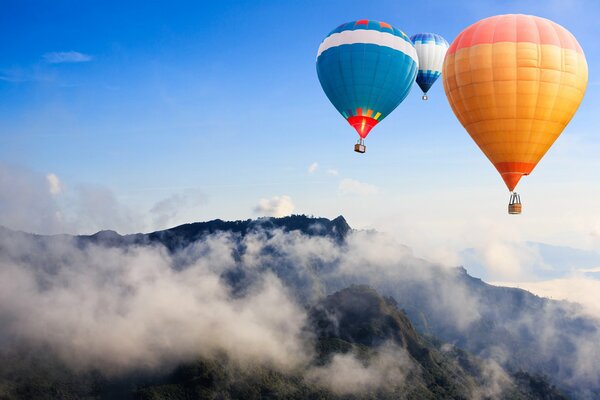 Globos que estropean sobre las montañas cubiertas de niebla