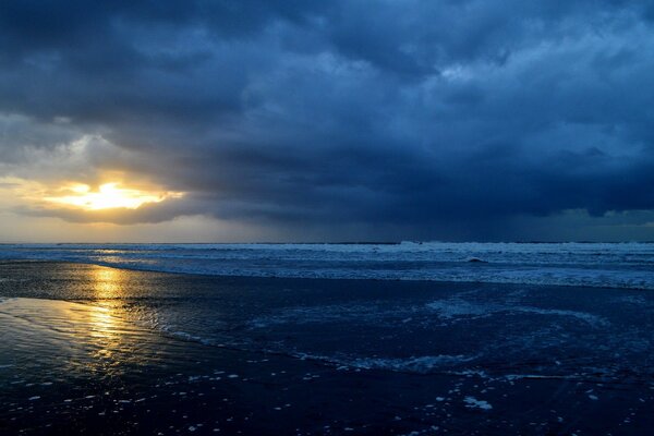 Nuages sombres et sombres sur les vagues et un rayon de soleil à travers les nuages