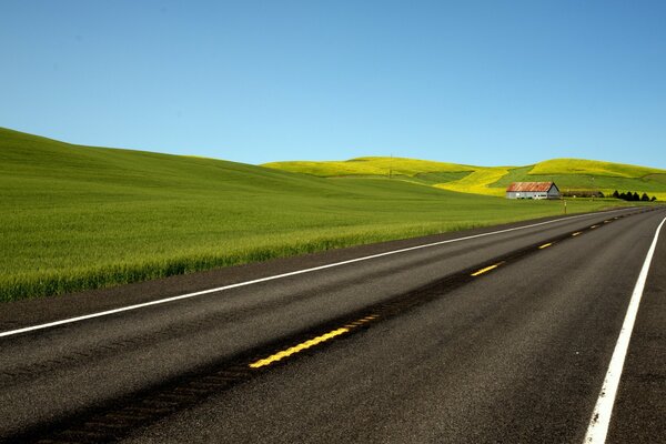 A long road with green fields