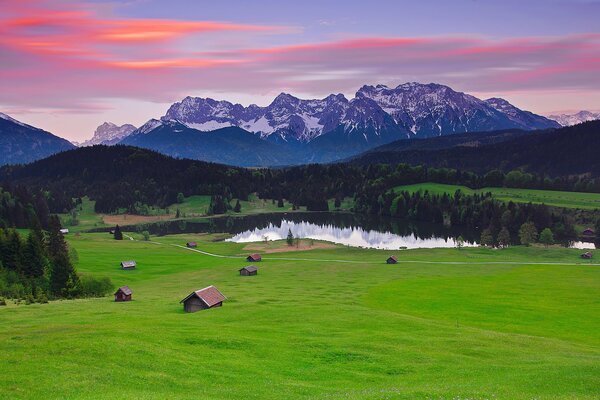 Wiese mit Häusern und See