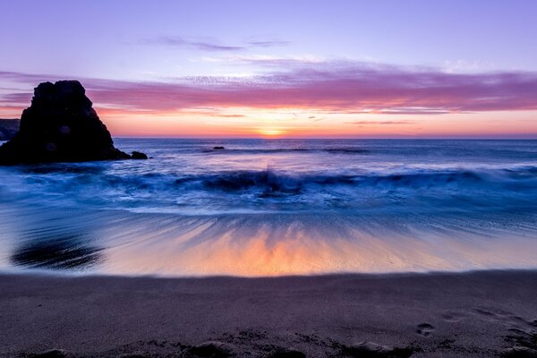 Rocky sea shore illuminated by sunset