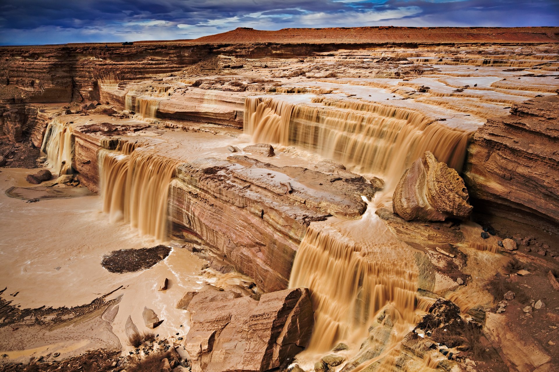 cascata di cioccolato flussi di fango fiume rocce canyon cielo nuvole