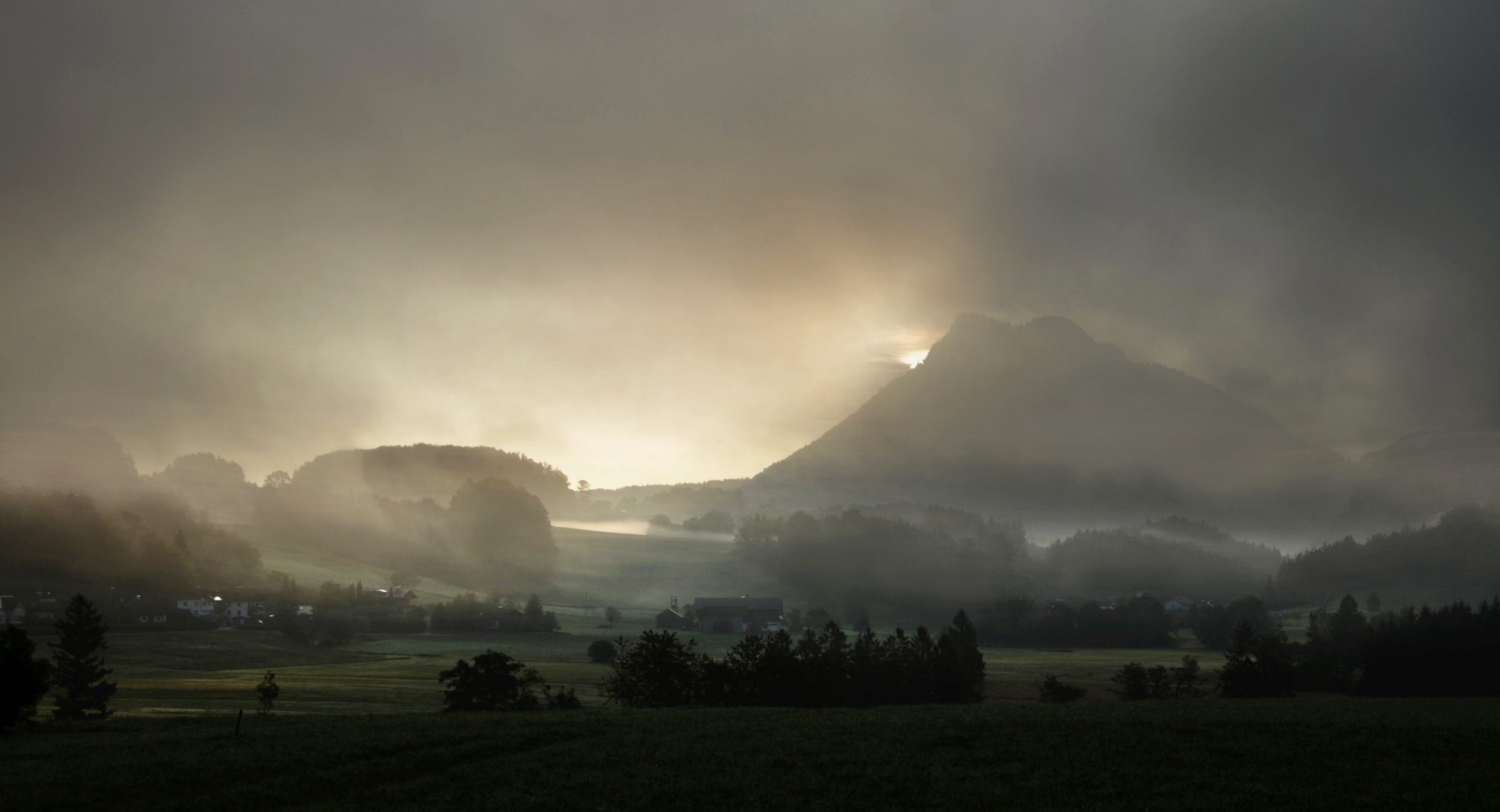 nebel berge häuser siedlung bäume felder gras