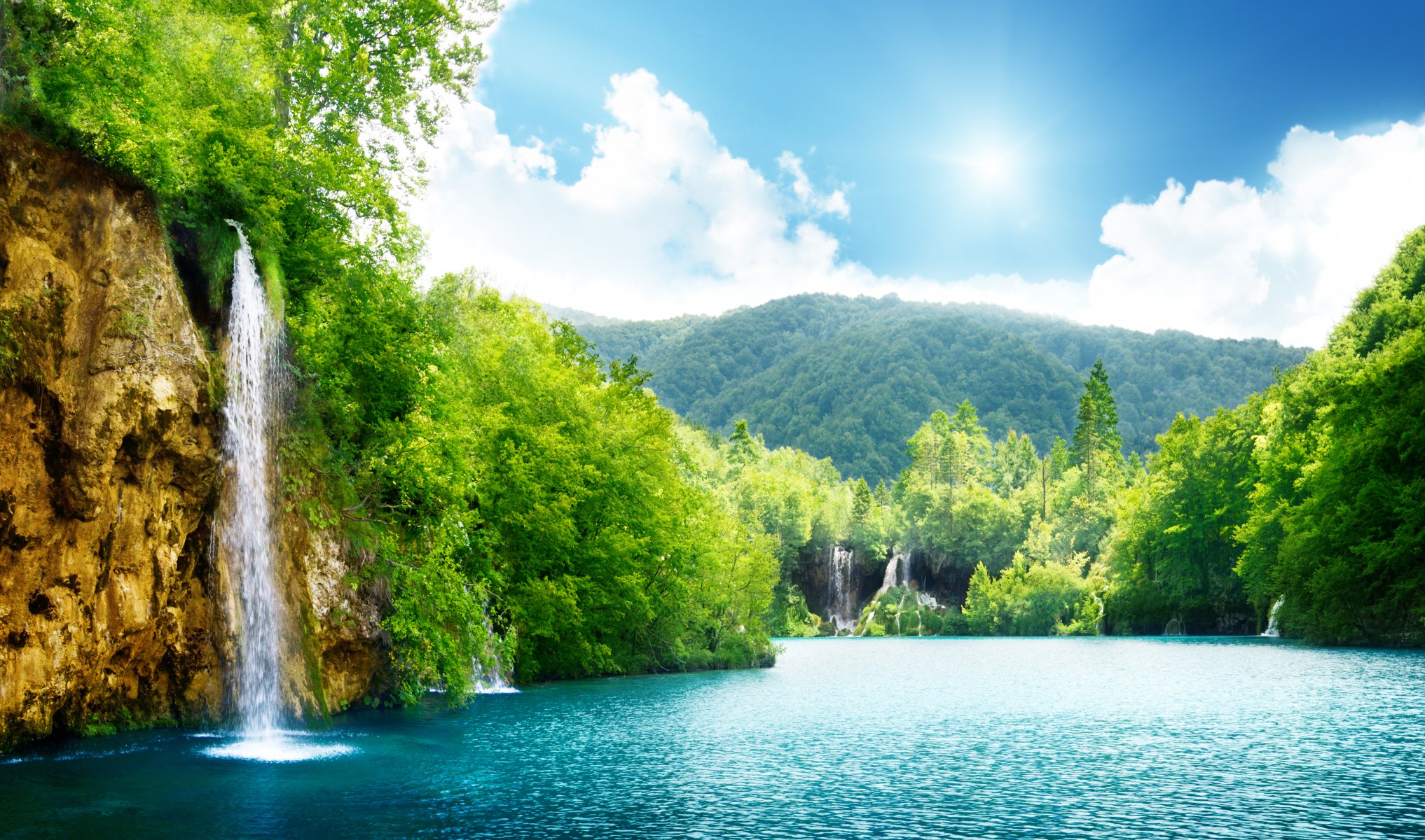 wasserfall meer see tiefer wald bäume himmel wolken landschaft natur dichter wald schön sonnenlicht