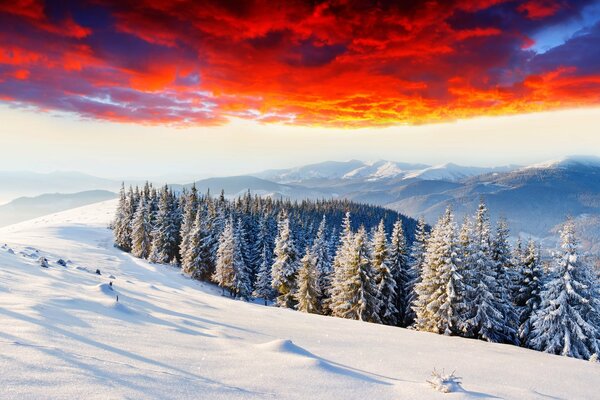 Resplandor en el cielo sobre las montañas cubiertas de nieve en la nieve