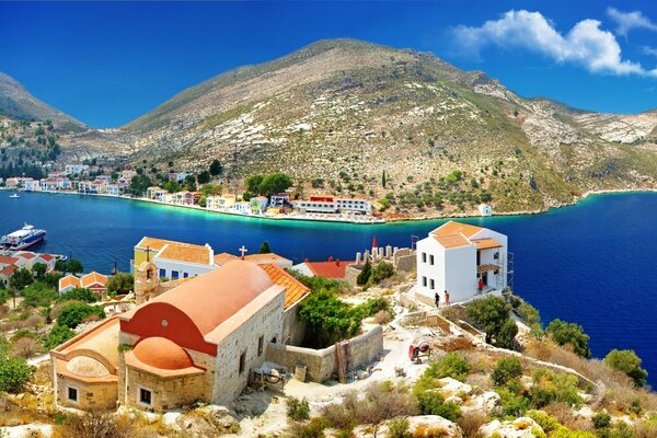 Casas e iglesia junto al mar en la soleada Grecia