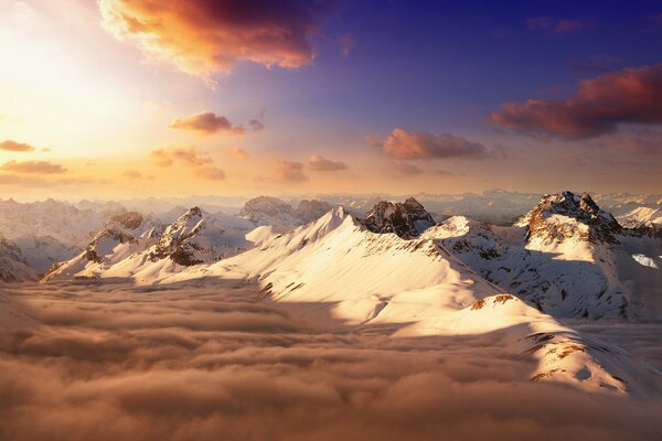 Sommets des montagnes enneigées sous les nuages