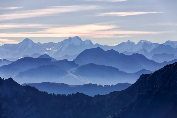 Montagne innevate blu e nuvole rosa