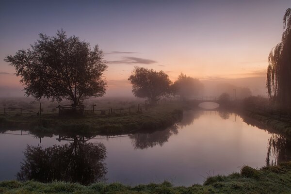 Paysage rustique simple avec rivière et brouillard du matin