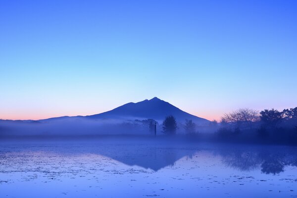 Reflejo del cielo azul de la tarde y la montaña