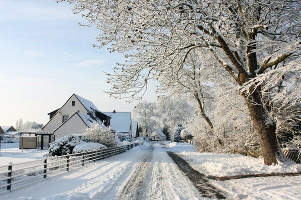 Cicha, zaśnieżona ulica z białymi domkami