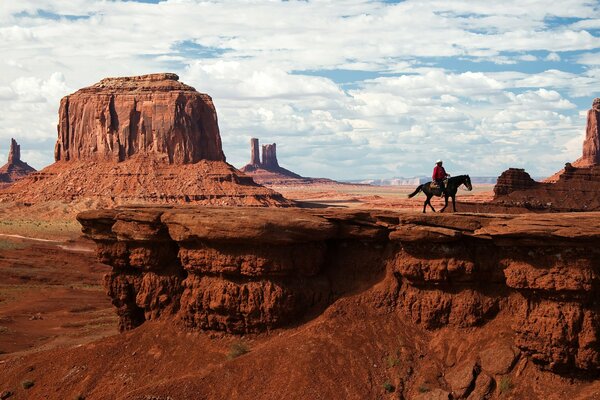 Un vaquero monta a caballo en el valle de los monumentos