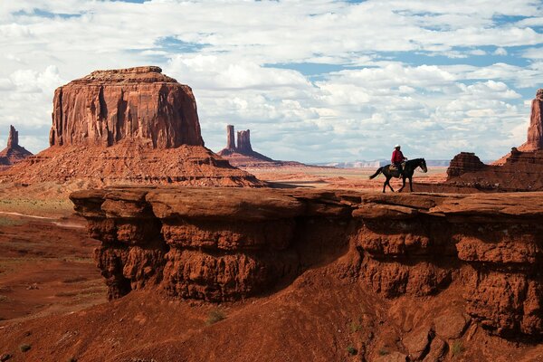 Ковбой едет на лошади в долине памятников