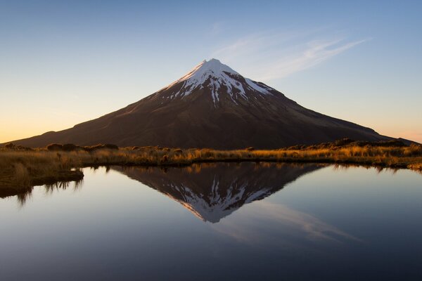 A volcano in New Zealand is reflected in a lake