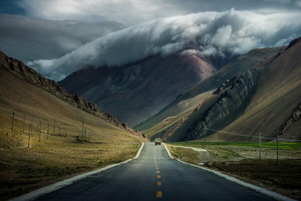 Die tibetischen Berge an der Straße unter den Wolken