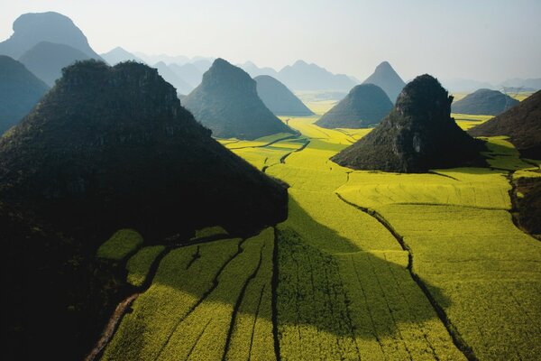 A green field with hills above a misty sky