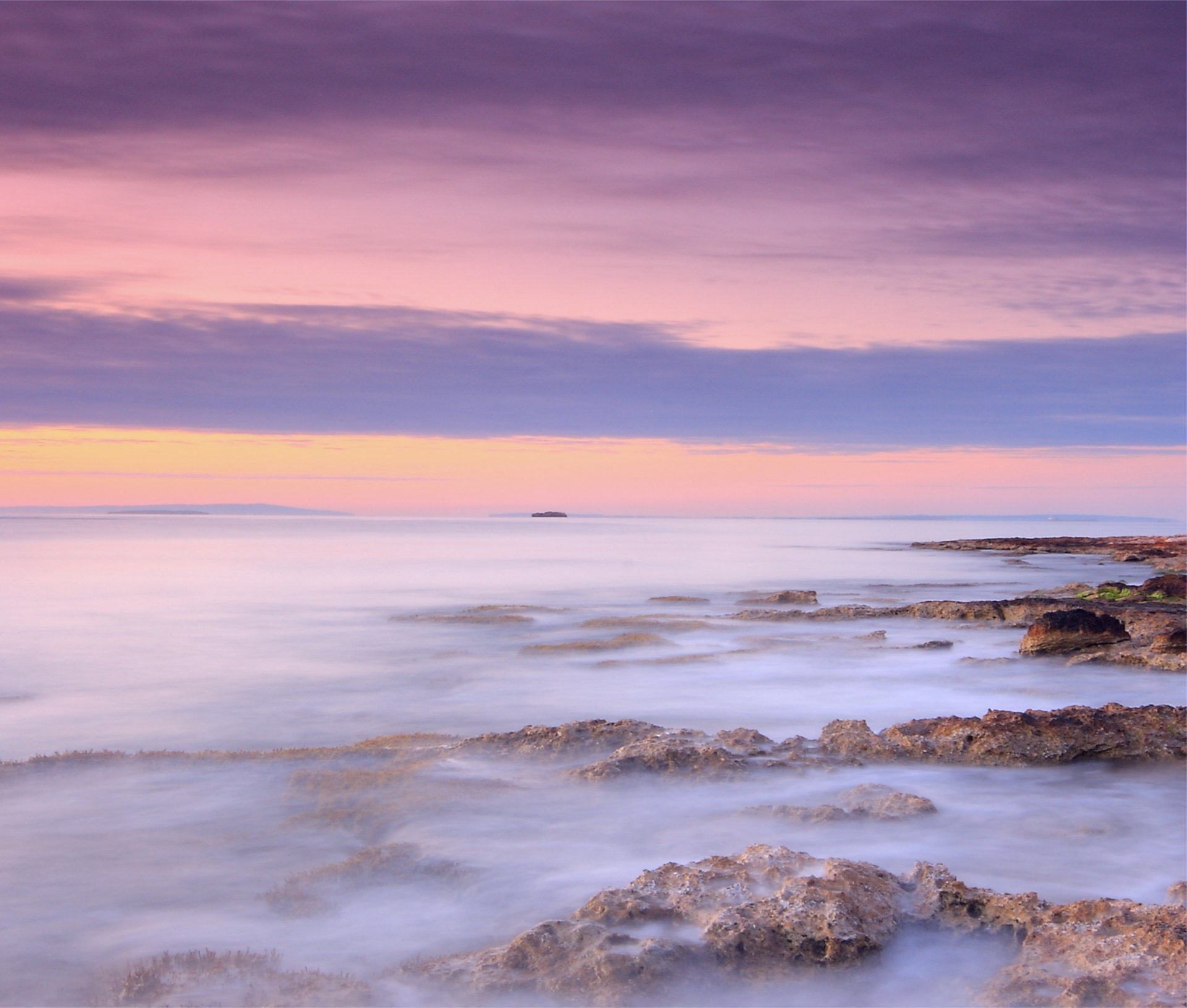 mar océano costa piedras noche naranja rosa lila puesta de sol cielo nubes