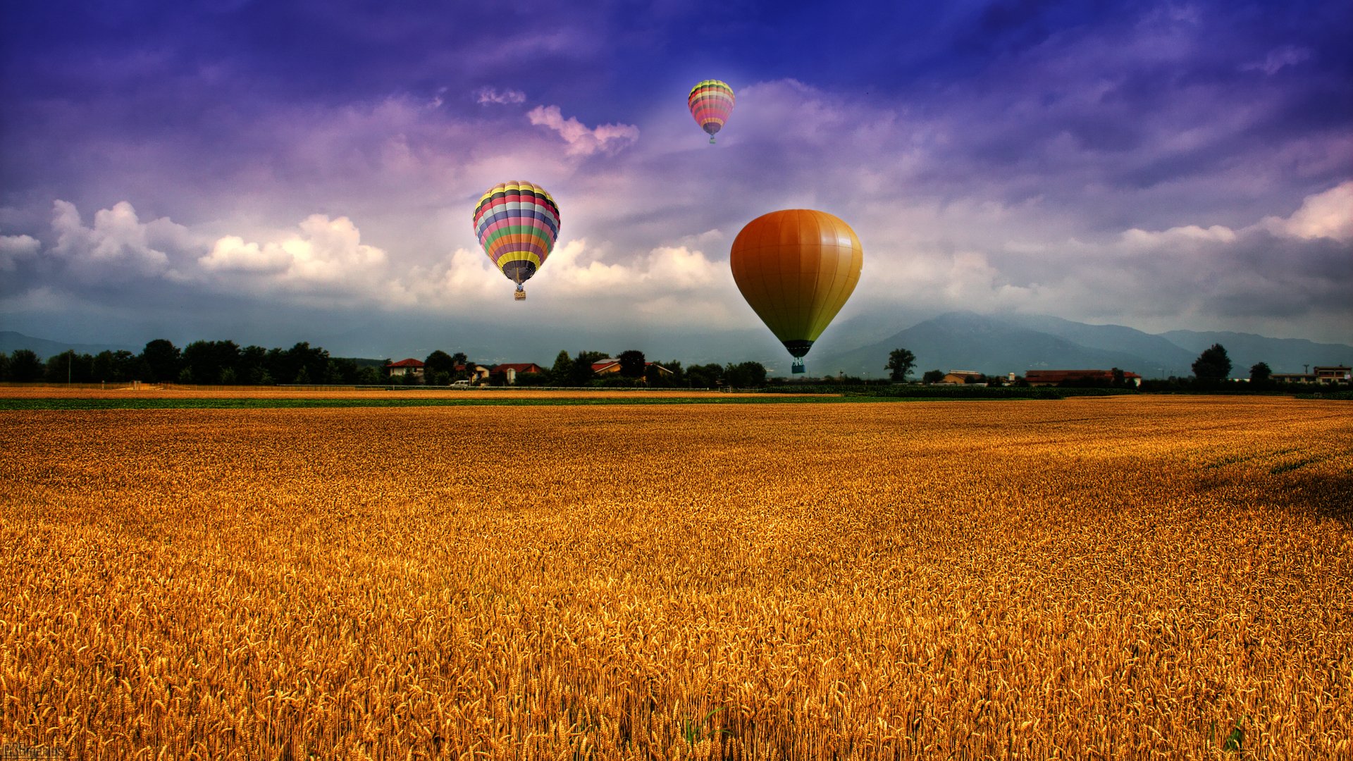 the field balloons sky clouds mountain houses village