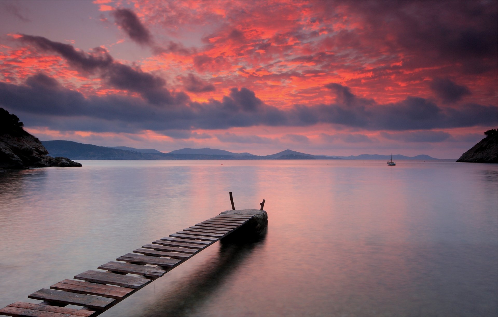 abend see wasser oberfläche stille holz brücke hell orange sonnenuntergang himmel wolken berge segel weg