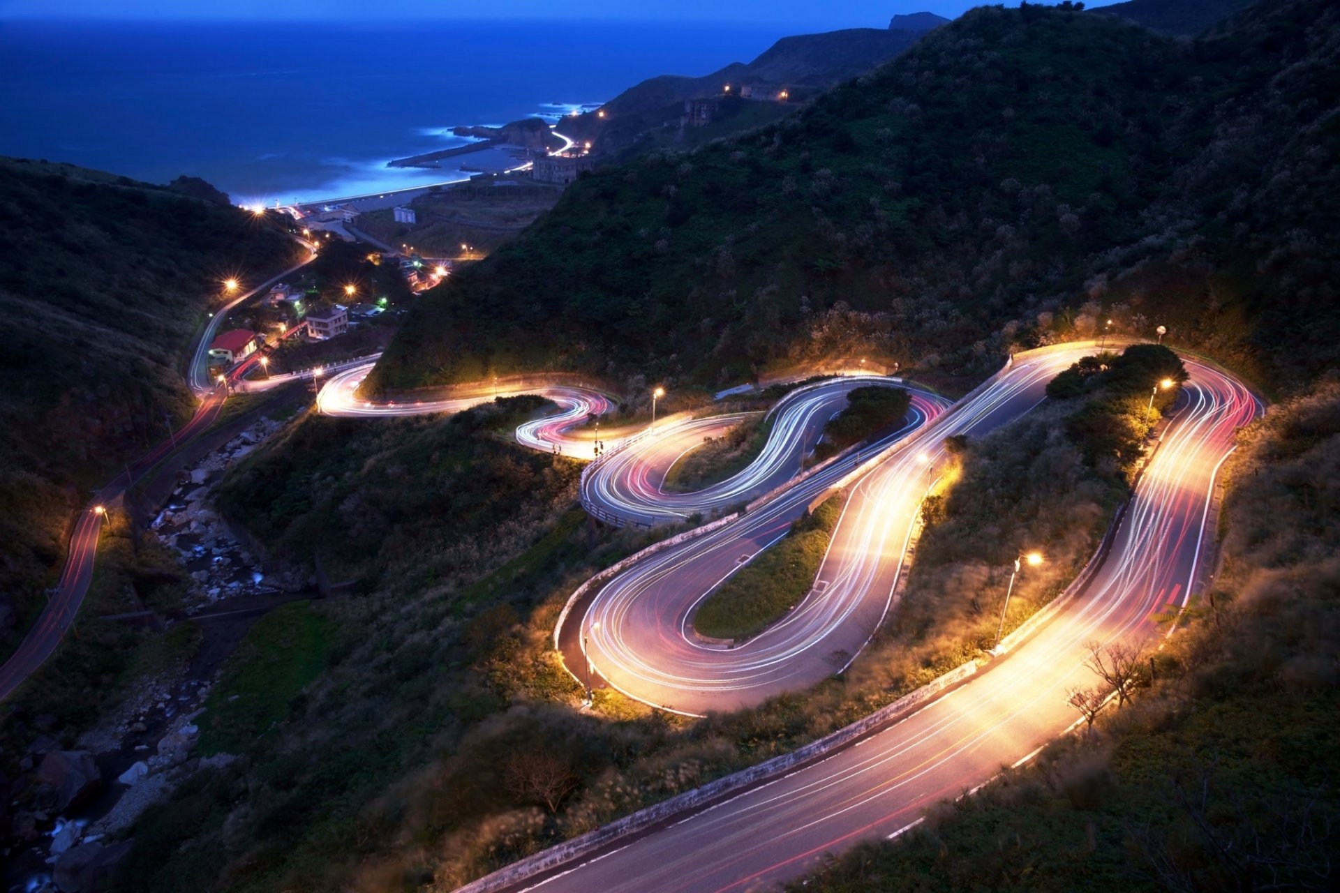 lope mountain road descent night lights sea