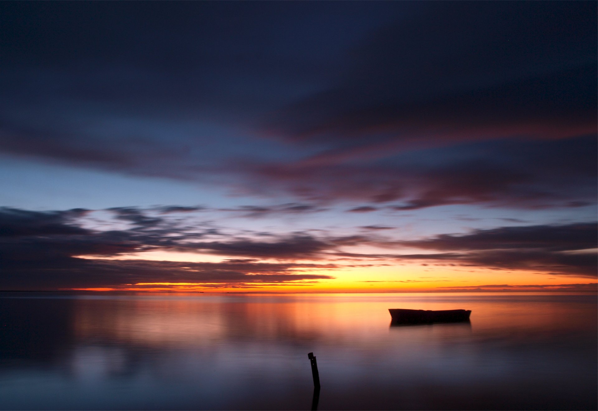 tarde puesta de sol cielo nubes nubes lago agua superficie reflexión barco madera columna