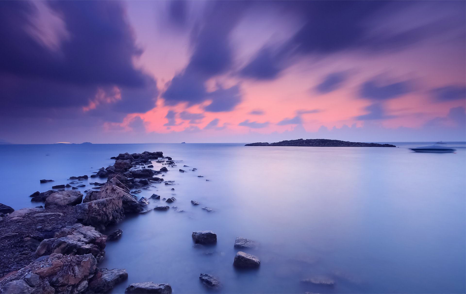 meer abend orange sonnenuntergang himmel wolken ufer steine wasser blau oberfläche ruhe boot weg