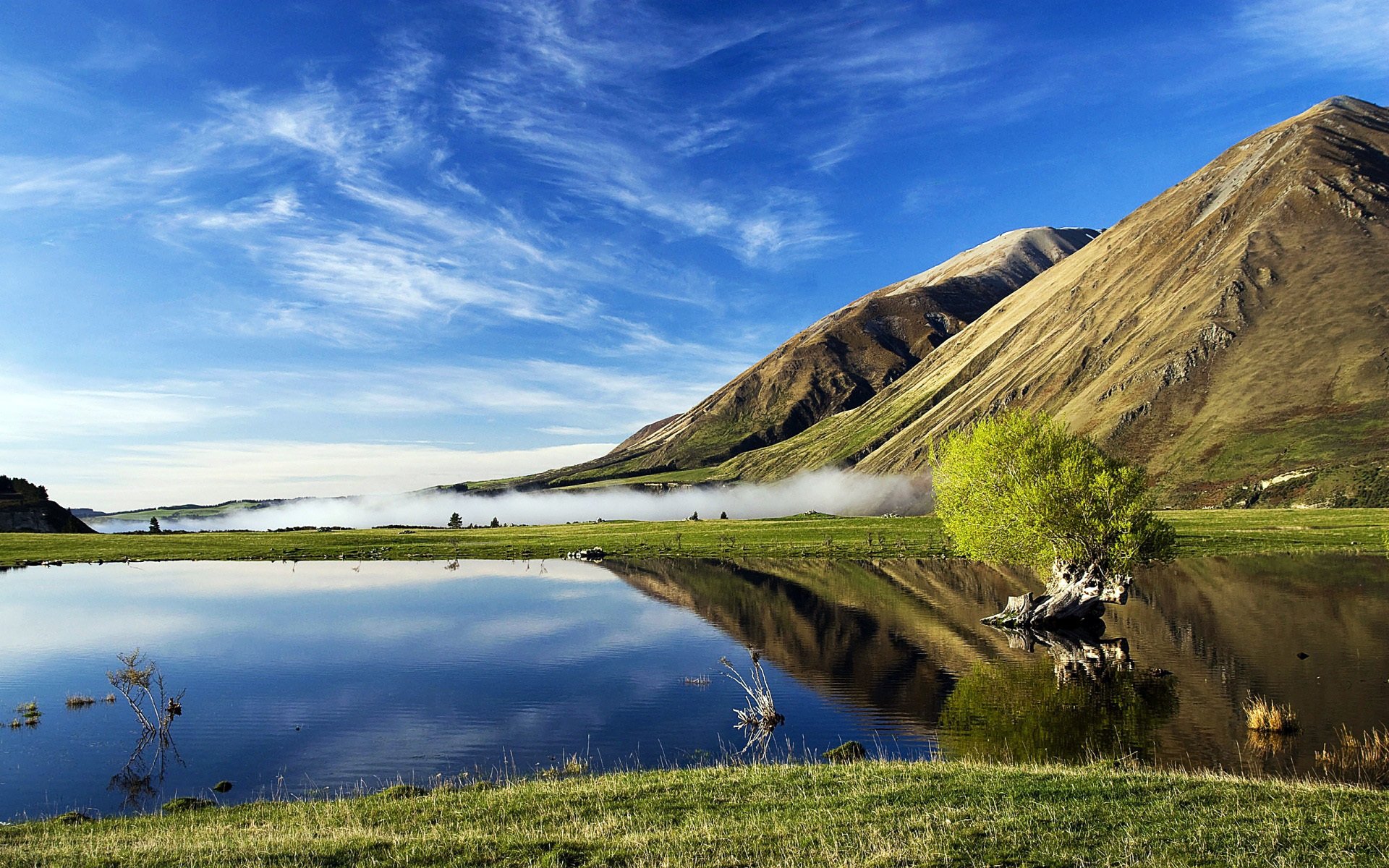 mountain slope meadow grass lake reservoirs surface of reflection spring nature the distance horizon sky cloud