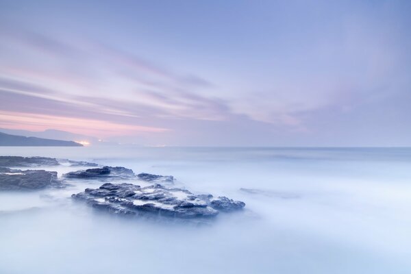 Aube brumeuse sur les rochers dans l océan