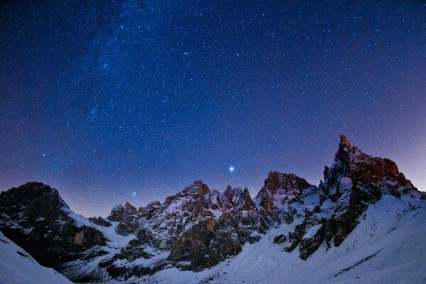 Paisaje nocturno estrellado con montañas