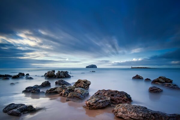 Cielo di colore del mare sopra le rocce della spiaggia