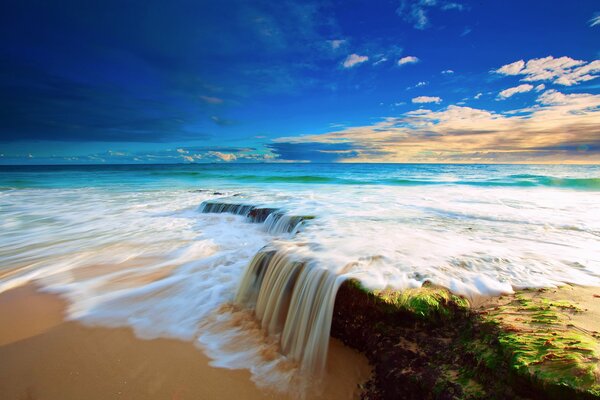 A small waterfall in the blue ocean