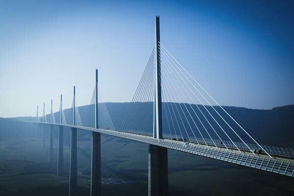 French bridge high above the water goes into the forest