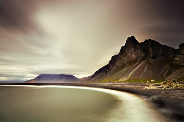 Mit Wolken bedeckte Berge am Meer