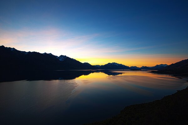 Le soleil se couche sur un lac de montagne